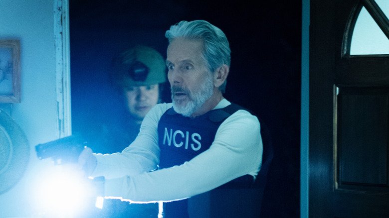 Alden Parker (Gary Cole) holding gun and flashlight, looking shocked, on 'ncis.'